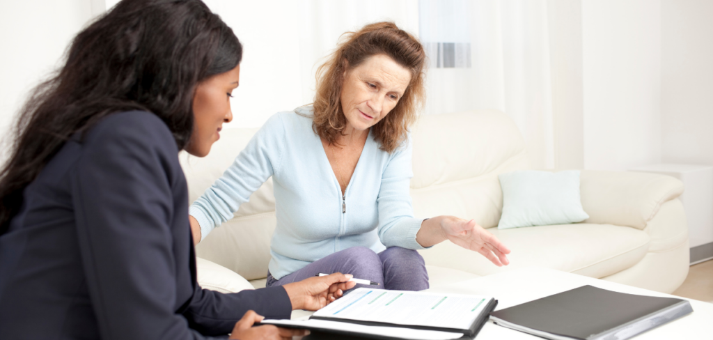 A senior woman meeting with a financial advisor at home.
