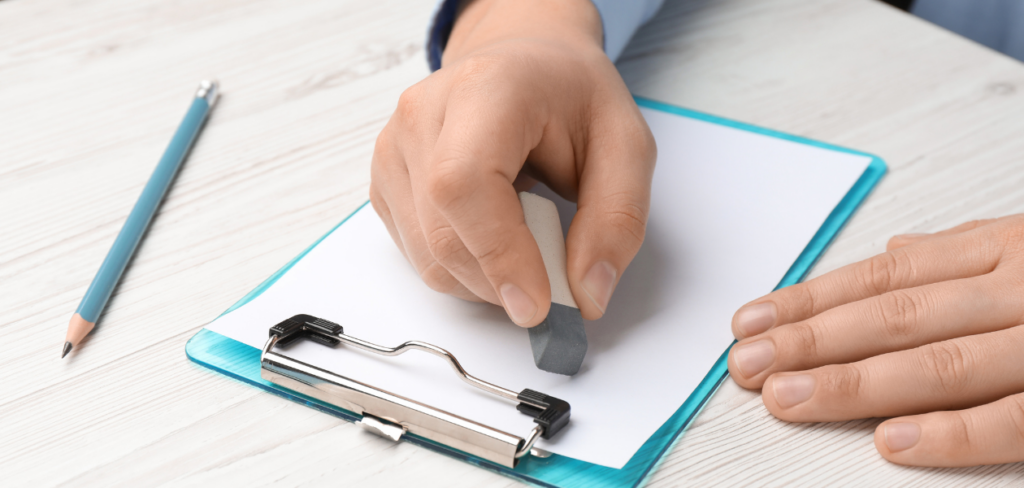 A person erasing something on a paper.
