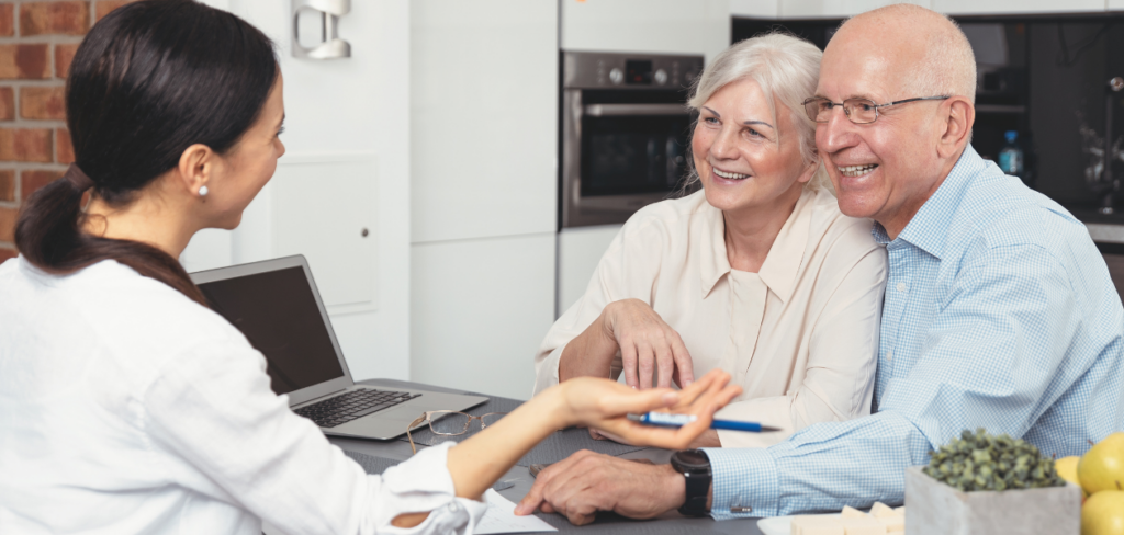 A happy senior couple is planning their investments with a financial advisor.
