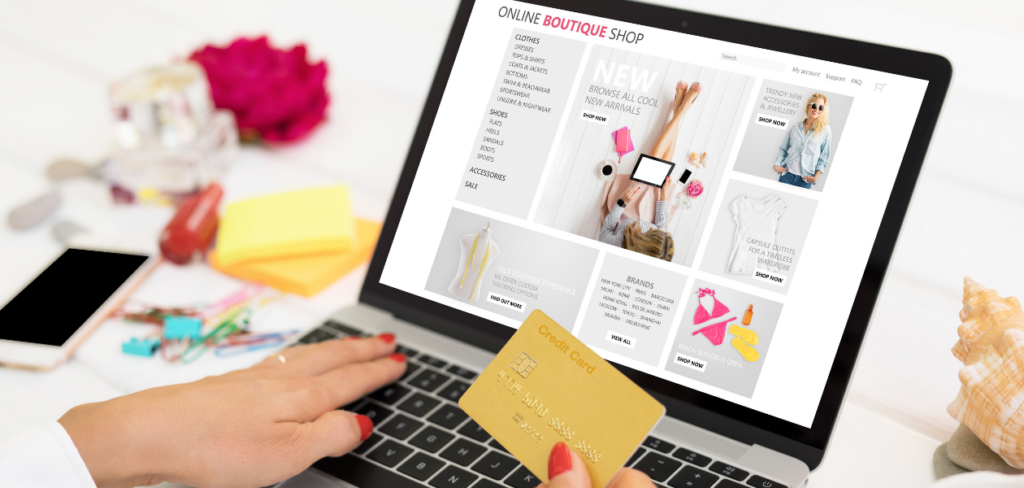 A woman is shopping online on her laptop while holding a credit card in her hand.
