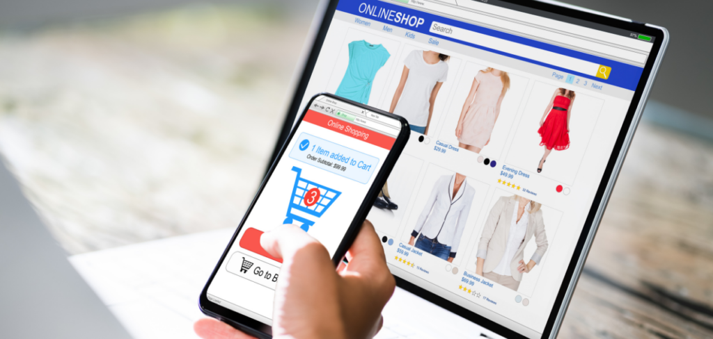 A person is shopping online for clothes using both their smartphone and laptop.
