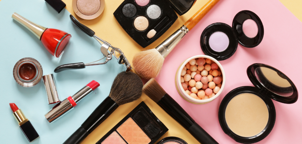 Makeup products arranged in a circle on a colorful background.