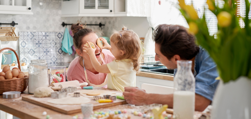 A family joyfully baking Easter cookies together in the kitchen.
