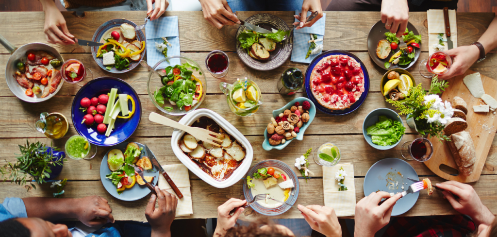 A group of people sitting around a table, enjoying a meal and having a chat.