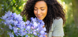 A woman enjoying the scent of fresh flowers in nature.