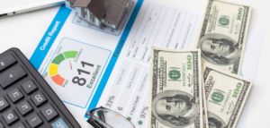Credit score concept with an excellent rating of 811, alongside cash, a calculator, and a house model.
