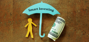 Paper cutouts of a person and an umbrella labeled 'Smart Investing,' with a rolled-up hundred-dollar bill next to them.