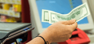 Close-up of a hand paying with a twenty-dollar bill.