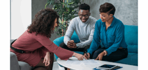 Financial advisor sitting with a couple, reviewing documents together and discussing financial planning.
